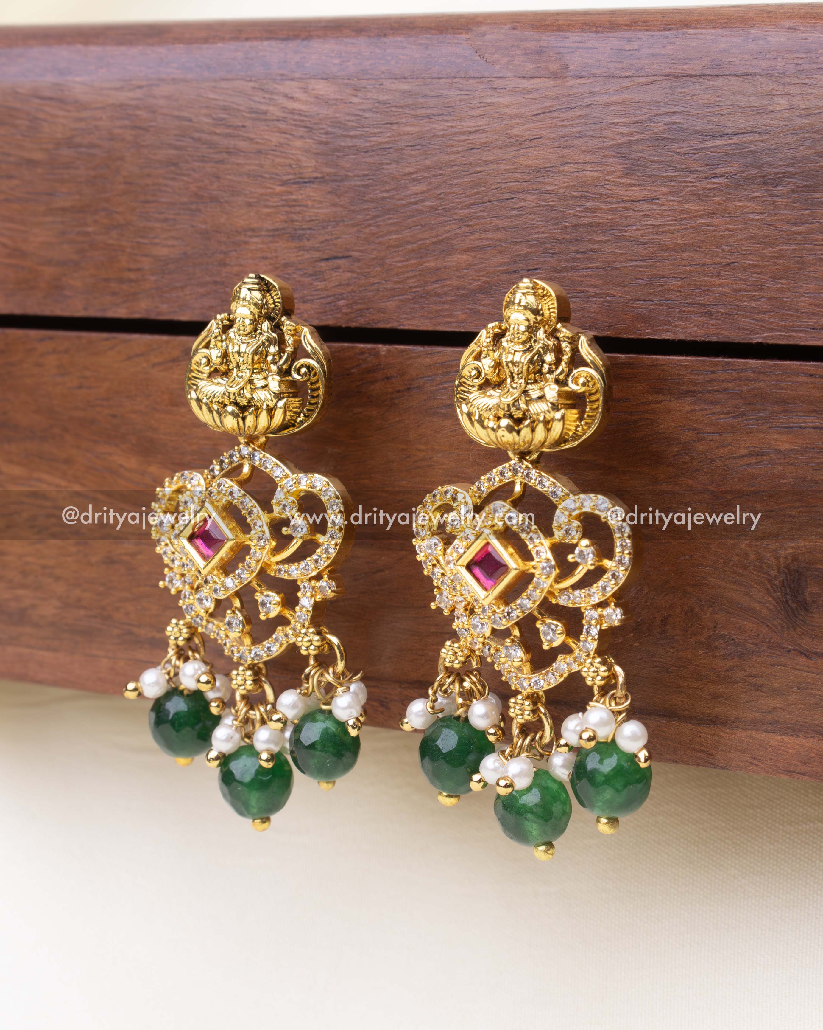 Temple jewelry earrings with emerald green beads and intricate CZ-studded floral frame.