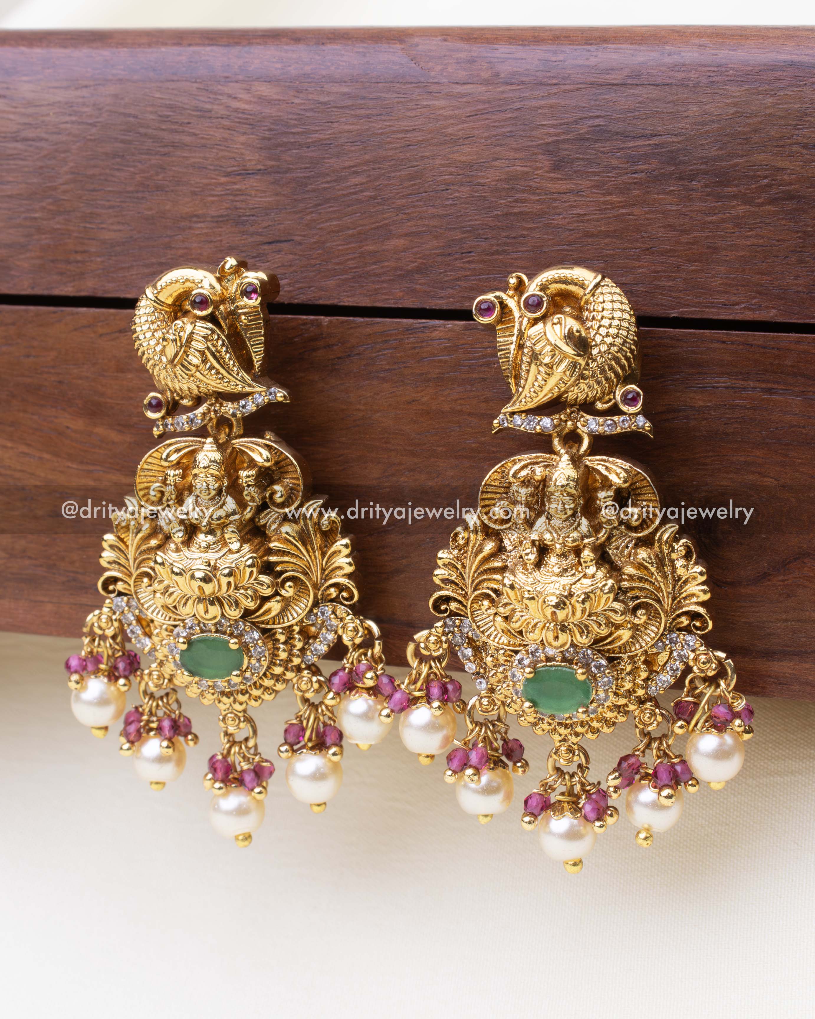 Elegant traditional earrings with peacock top, Lakshmi design, and pink bead clusters.