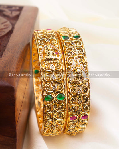 Side angle showing temple-style craftsmanship and embossed goddess motif on antique gold bangle.