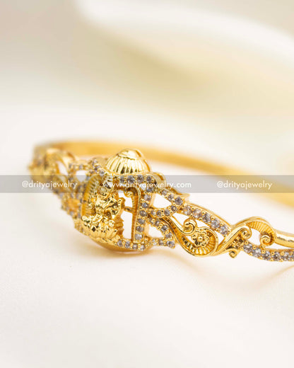 Gold temple kada with intricate scrollwork and sparkling CZ embellishments.