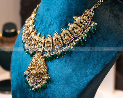 Side view of the gold-plated temple necklace from Dritya Jewelry, featuring detailed temple-inspired designs with green beads and pearls.