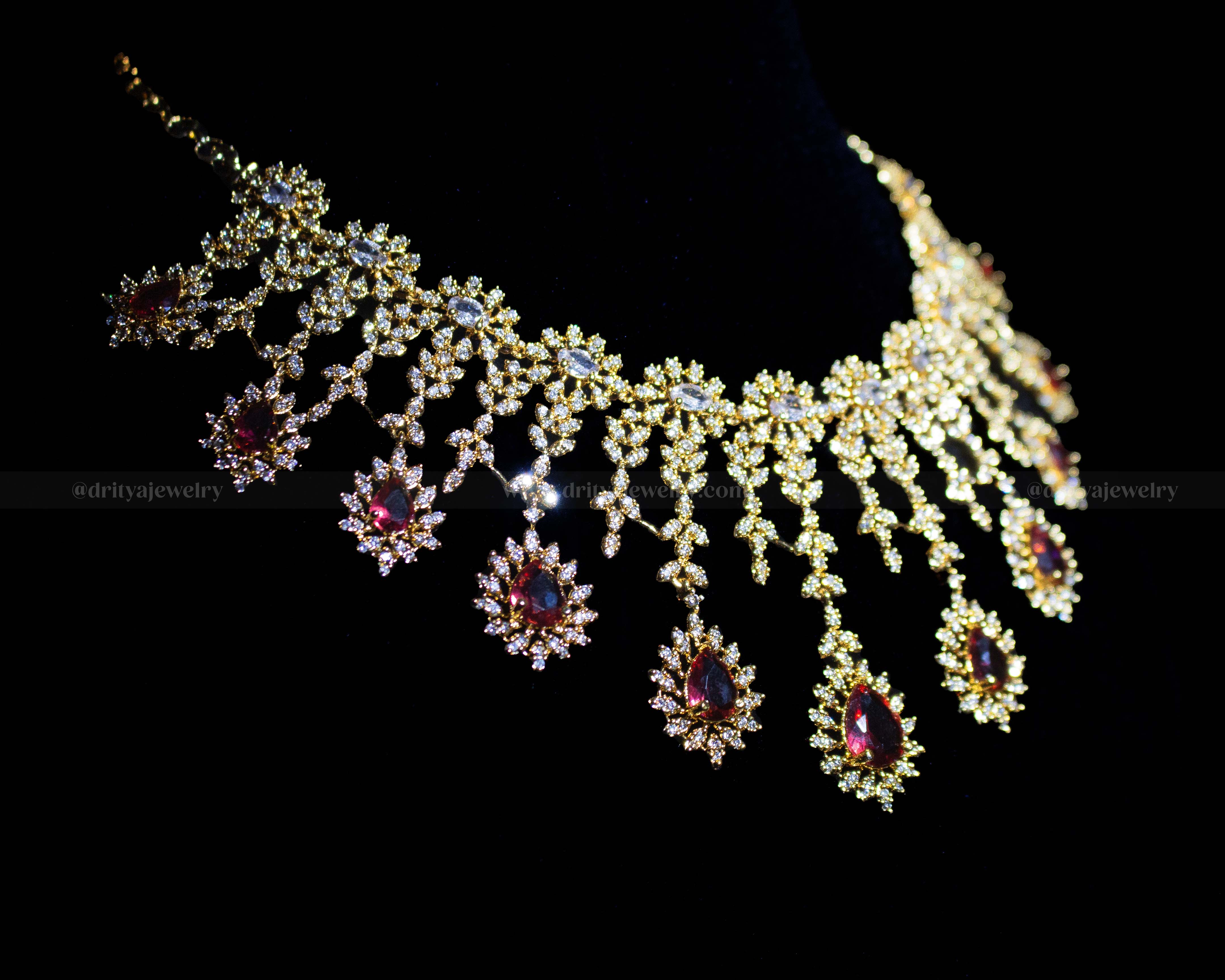 Side perspective showing the detailed arrangement of cubic zirconia and garnet stones in floral motifs.