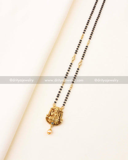 Double-line black beads necklace with temple-style Lakshmi pendant and pearl drop.