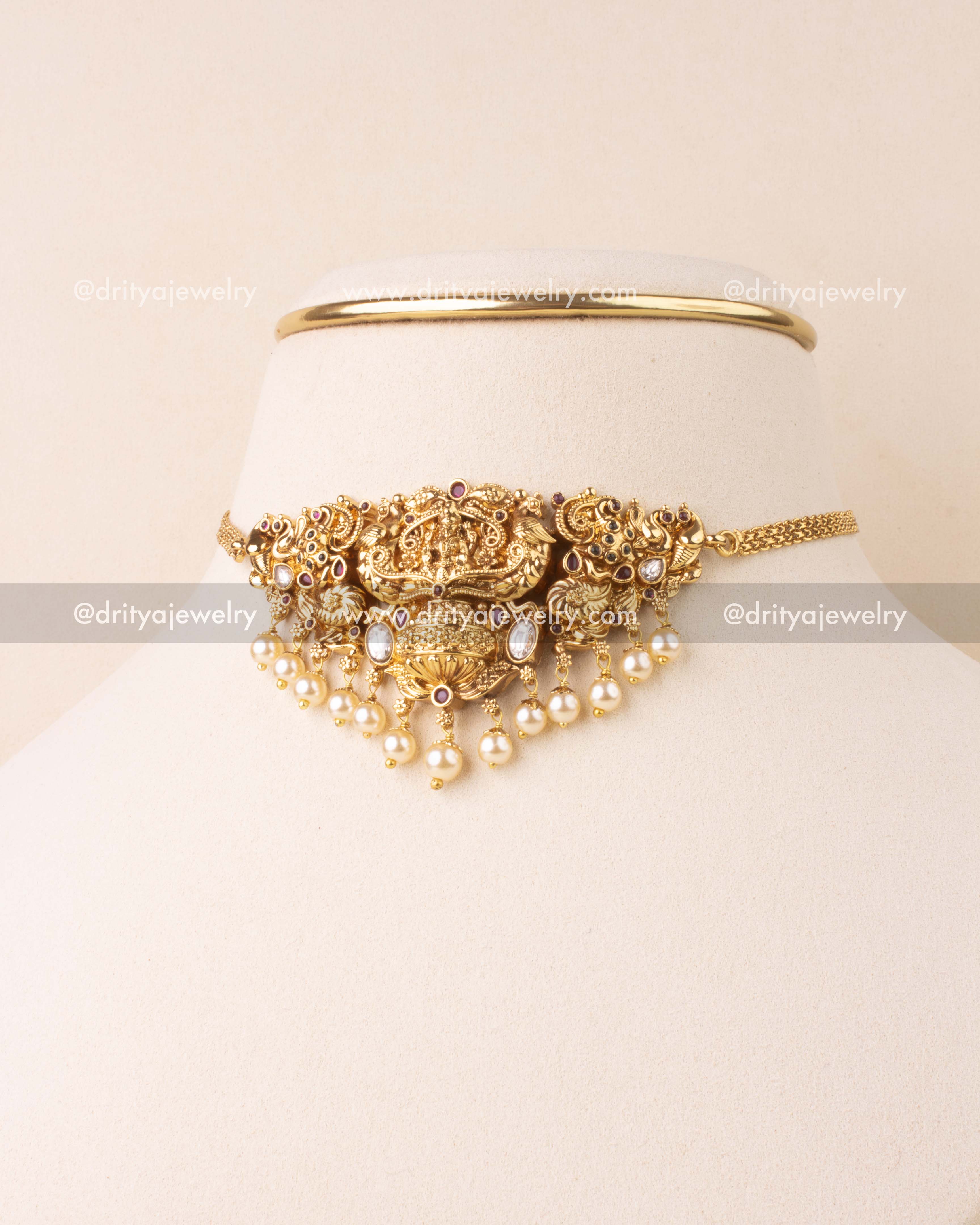 Temple choker featuring Lakshmi design, pearl drops, and antique gold finish