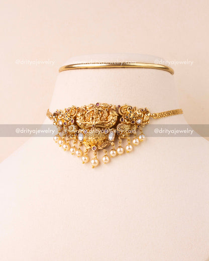Temple choker featuring Lakshmi design, pearl drops, and antique gold finish