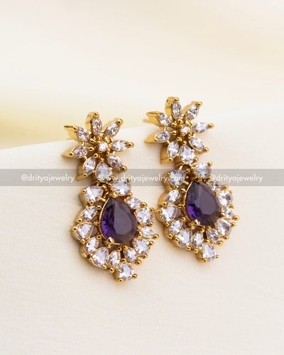 Elegant gold earrings with violet stones and clustered CZ design.