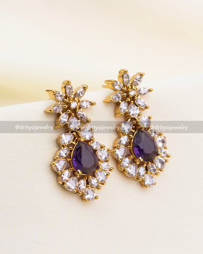 Elegant gold earrings with violet stones and clustered CZ design.