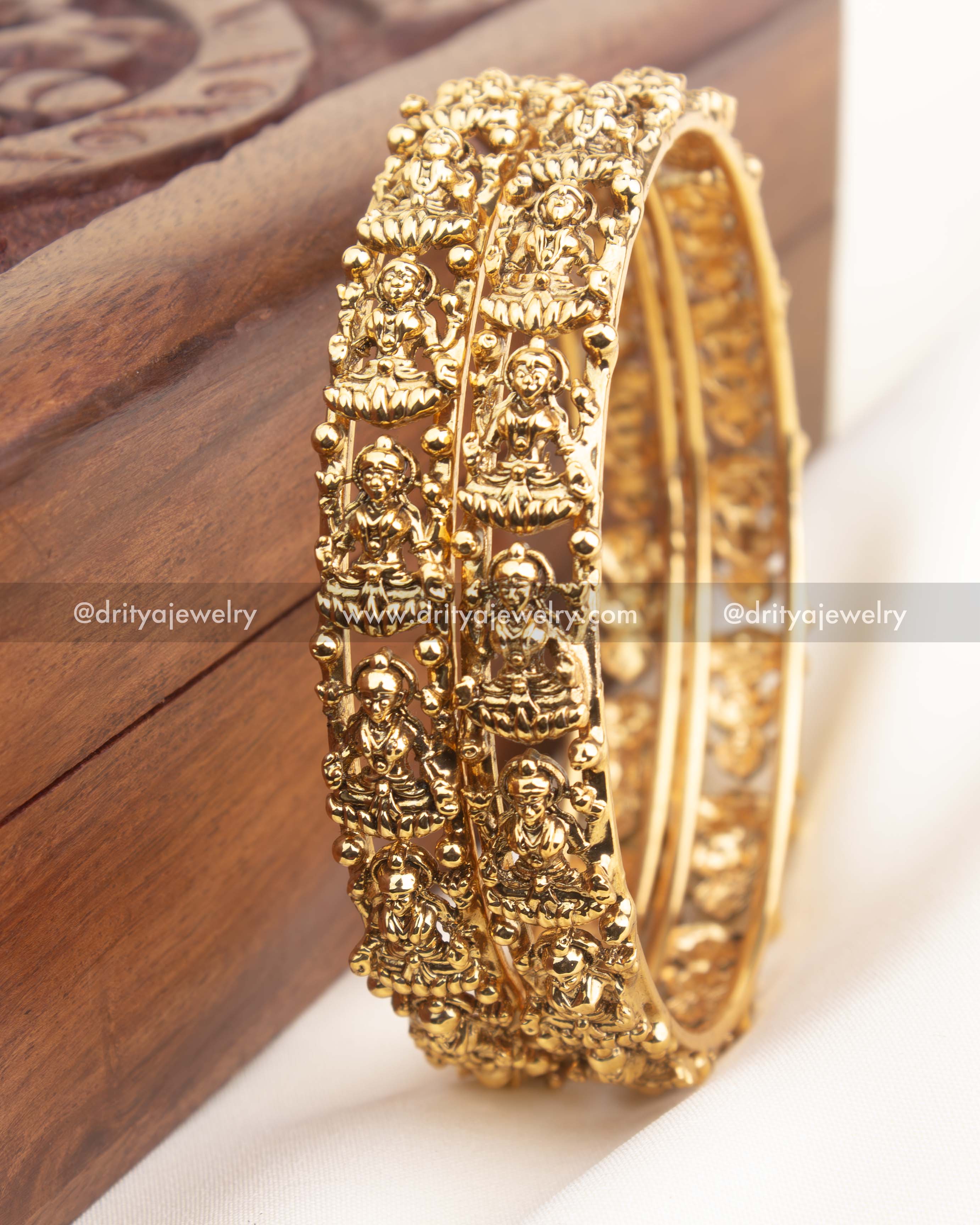Pair of high-gold temple bangles with repeating Lakshmi motifs and granulated bead edges.