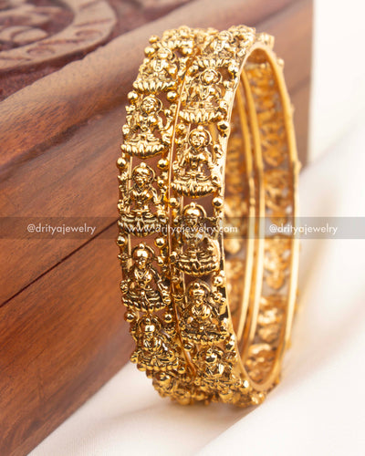 Pair of high-gold temple bangles with repeating Lakshmi motifs and granulated bead edges.
