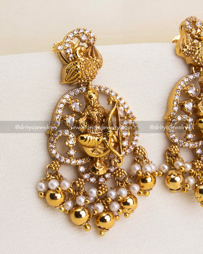 Temple-style dangler earrings with deity design, CZ accents, and golden bead drops.