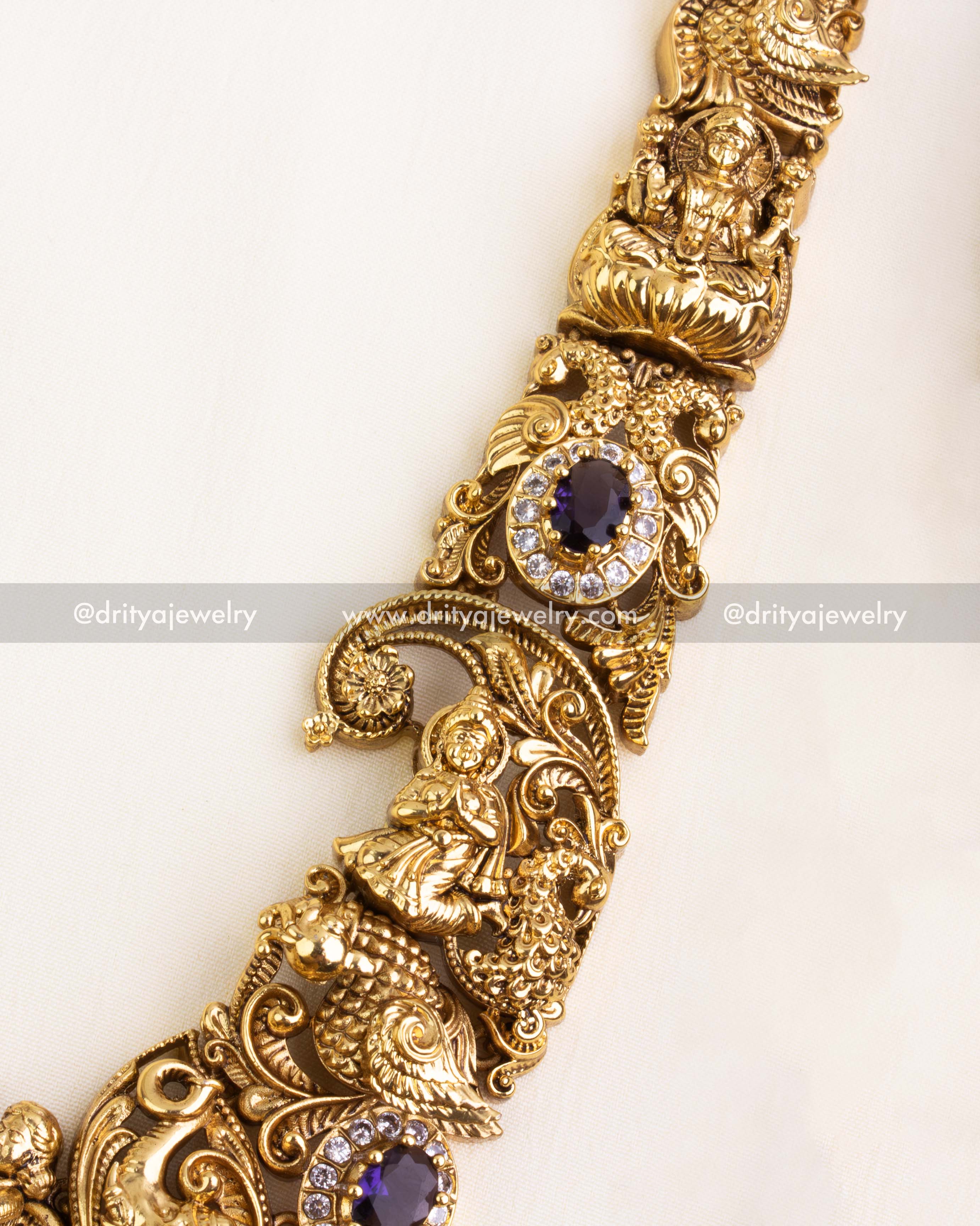 Detailed look at the Nakshi chain links with raised floral patterns and embedded purple stones