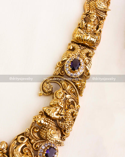 Detailed look at the Nakshi chain links with raised floral patterns and embedded purple stones