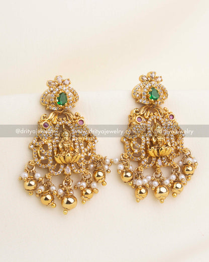 Matching gold-plated temple earrings with green stones, CZ work, Lakshmi motif, and pearl jumkhi drops.