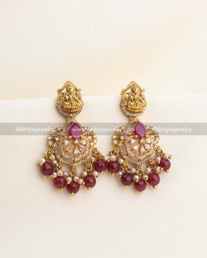 Ruby red temple earrings with CZ work, Lakshmi idol top, and pearl-bead detailing.