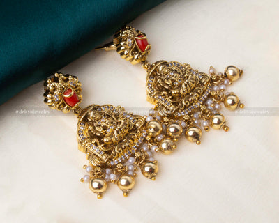 Matching temple-style earrings with red accents and pearl embellishments.