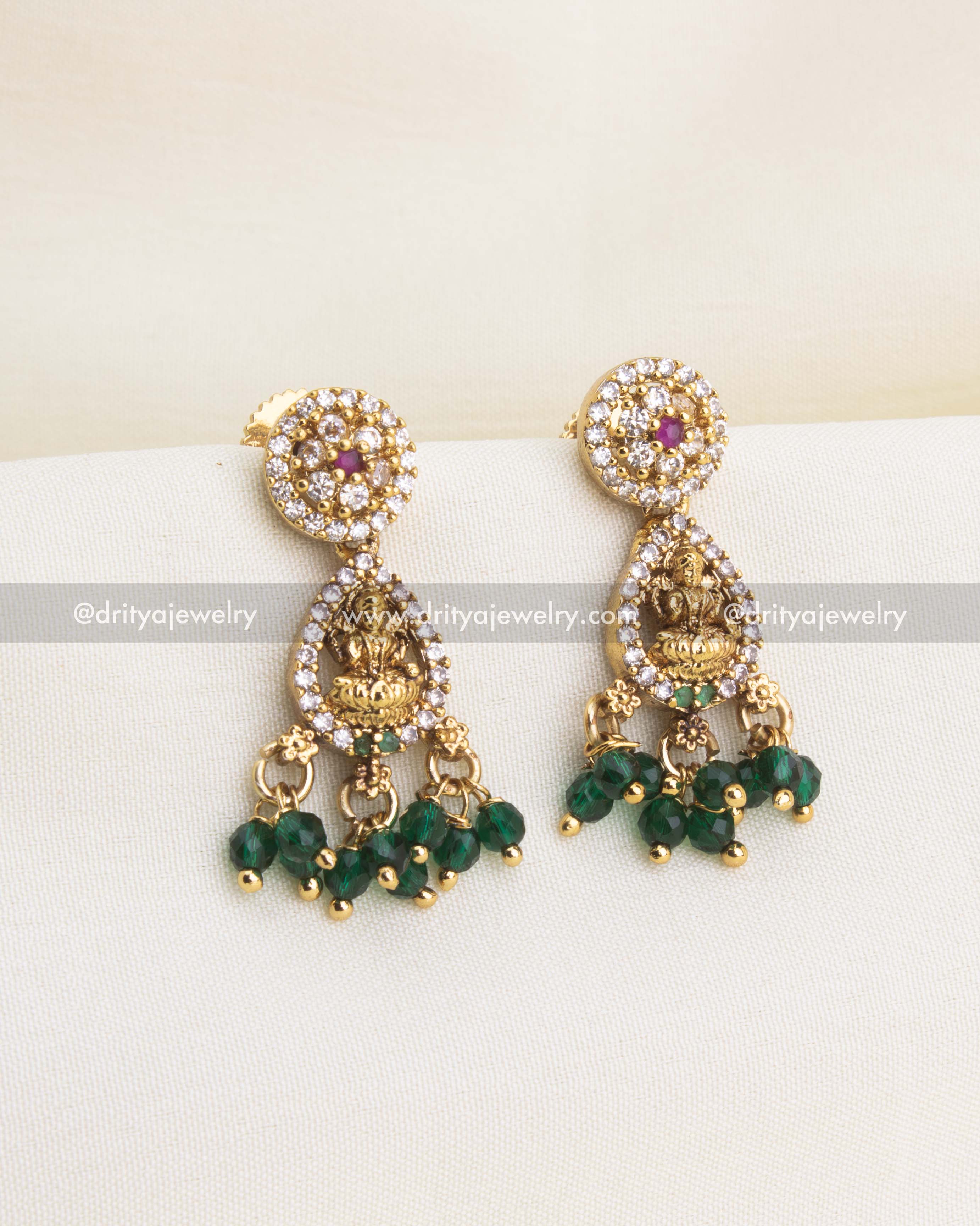 Matching Lakshmi earrings with CZ framing and dangling green bead drops in gold finish.