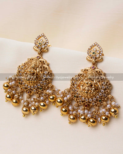 Exquisite Nakshi-style temple earrings with intricate detailing, white stones, and pearl danglers.