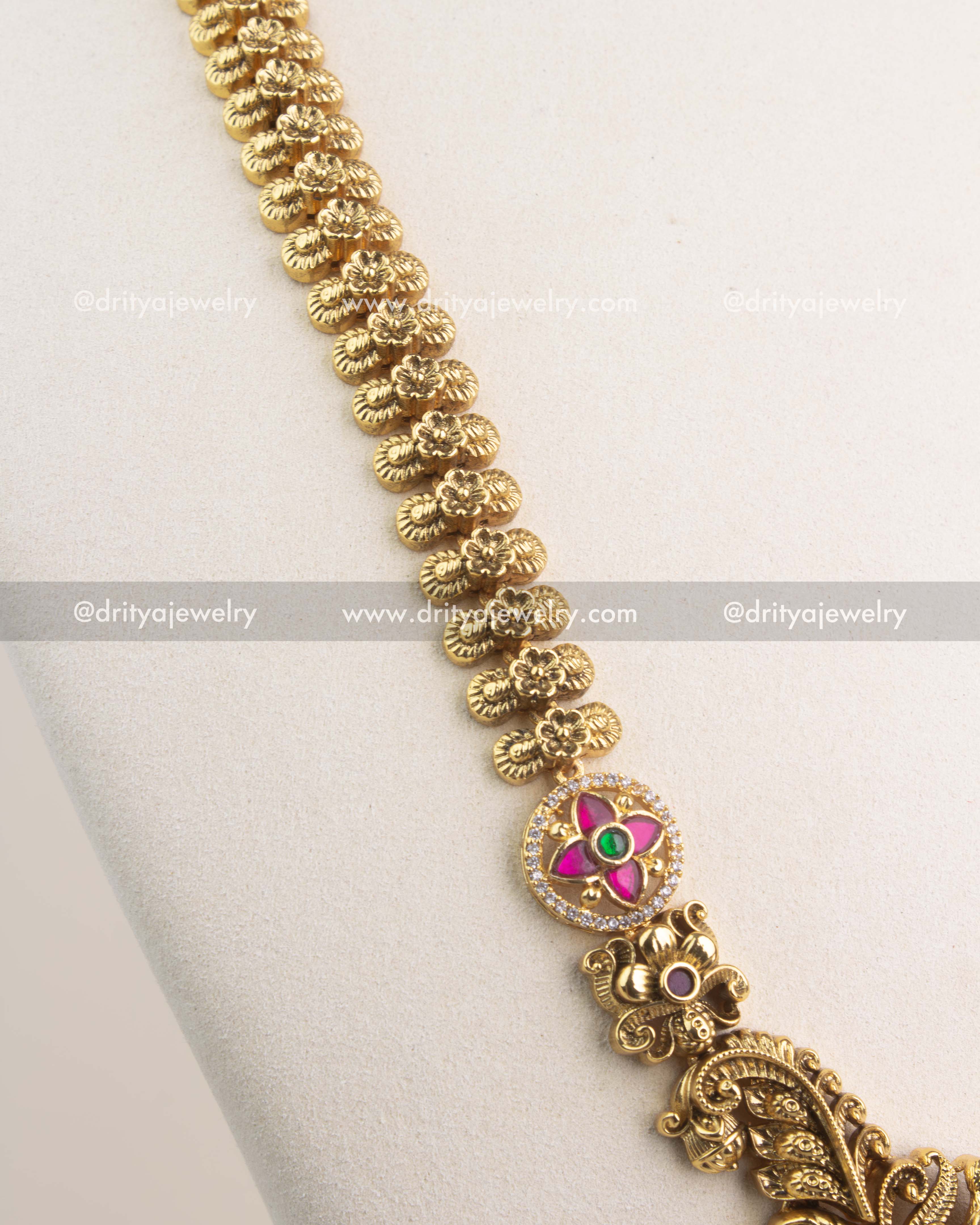 Close-up of peacock and floral motifs with antique gold polish and Kemp stone accents.