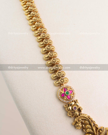 Close-up of peacock and floral motifs with antique gold polish and Kemp stone accents.