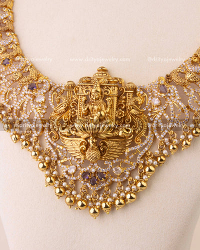 Close-up of temple-style Nakshi necklace with intricate peacock motifs and gold bead accents.