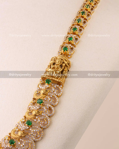 Close-up of Nakshi temple necklace with intricate peacock motifs and faceted green bead hangings.