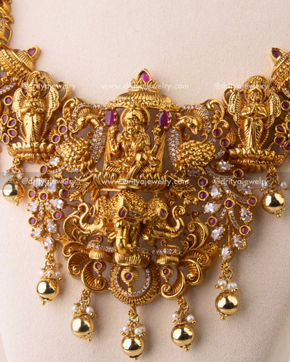Close-up of antique temple necklace with peacock, elephant, and deity engravings embellished with Kemp stones.