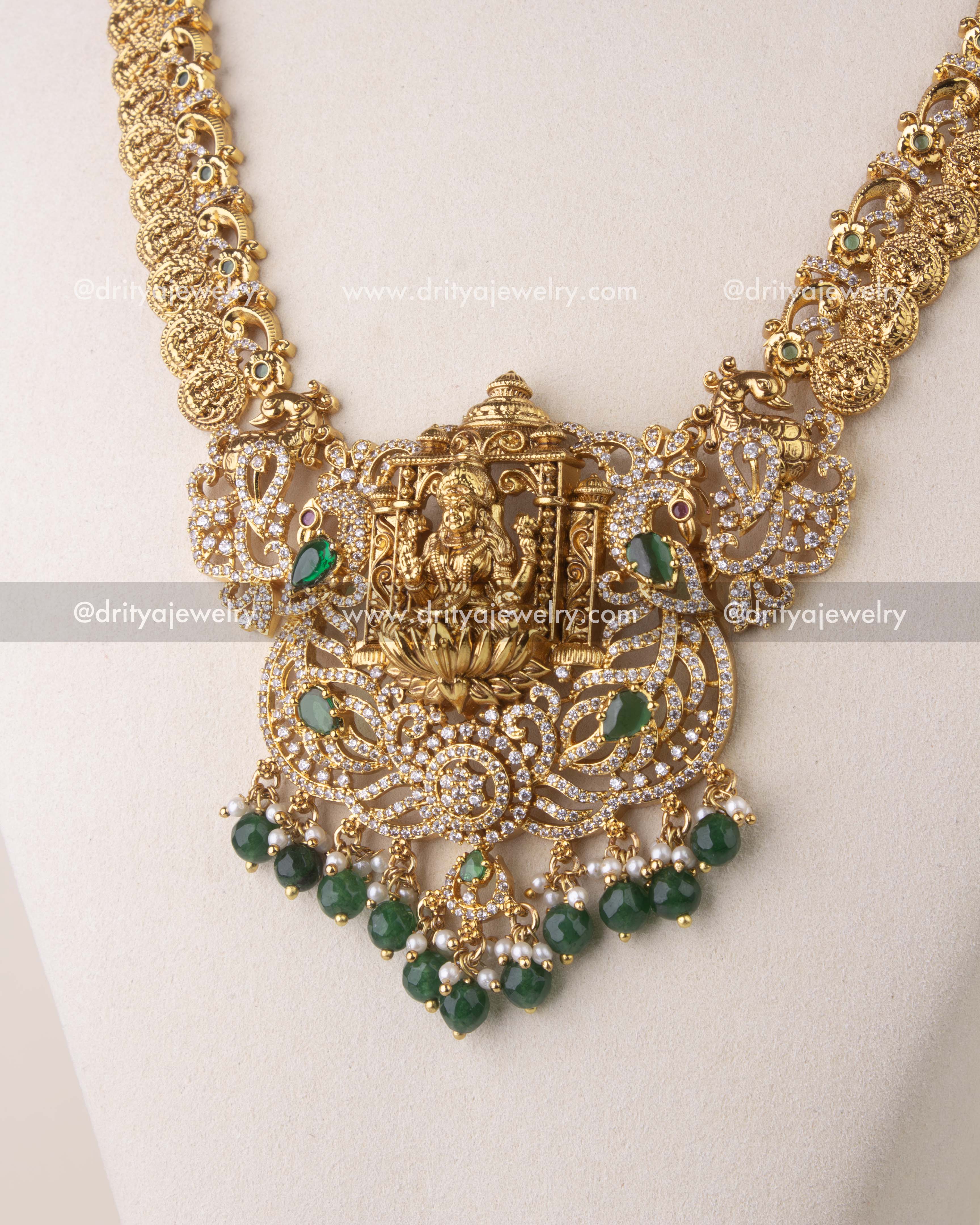 Close-up of Kasulu chain long necklace with Nakshi coin details, green accents, and CZ stone embellishments.