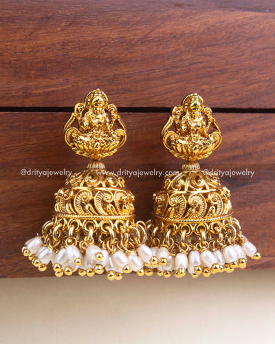 Gold temple jhumka with Lakshmi stud and rice bead pearl hangings, crafted in antique gold polish.