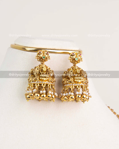 Antique gold temple jhumkas with nakshi detailing, pearls, and gold beads.