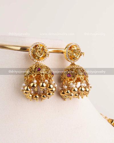 Traditional jhumka earrings with deity motif, kemp accents, and gold bead clusters.