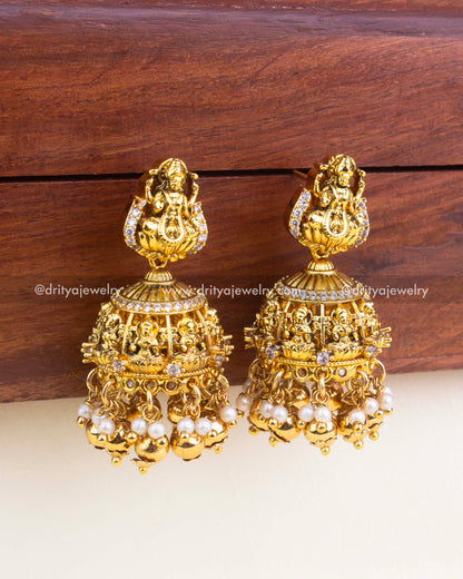 Lakshmi Nakshi jhumka earrings with CZ stones, pearl hangings, and antique gold finish.