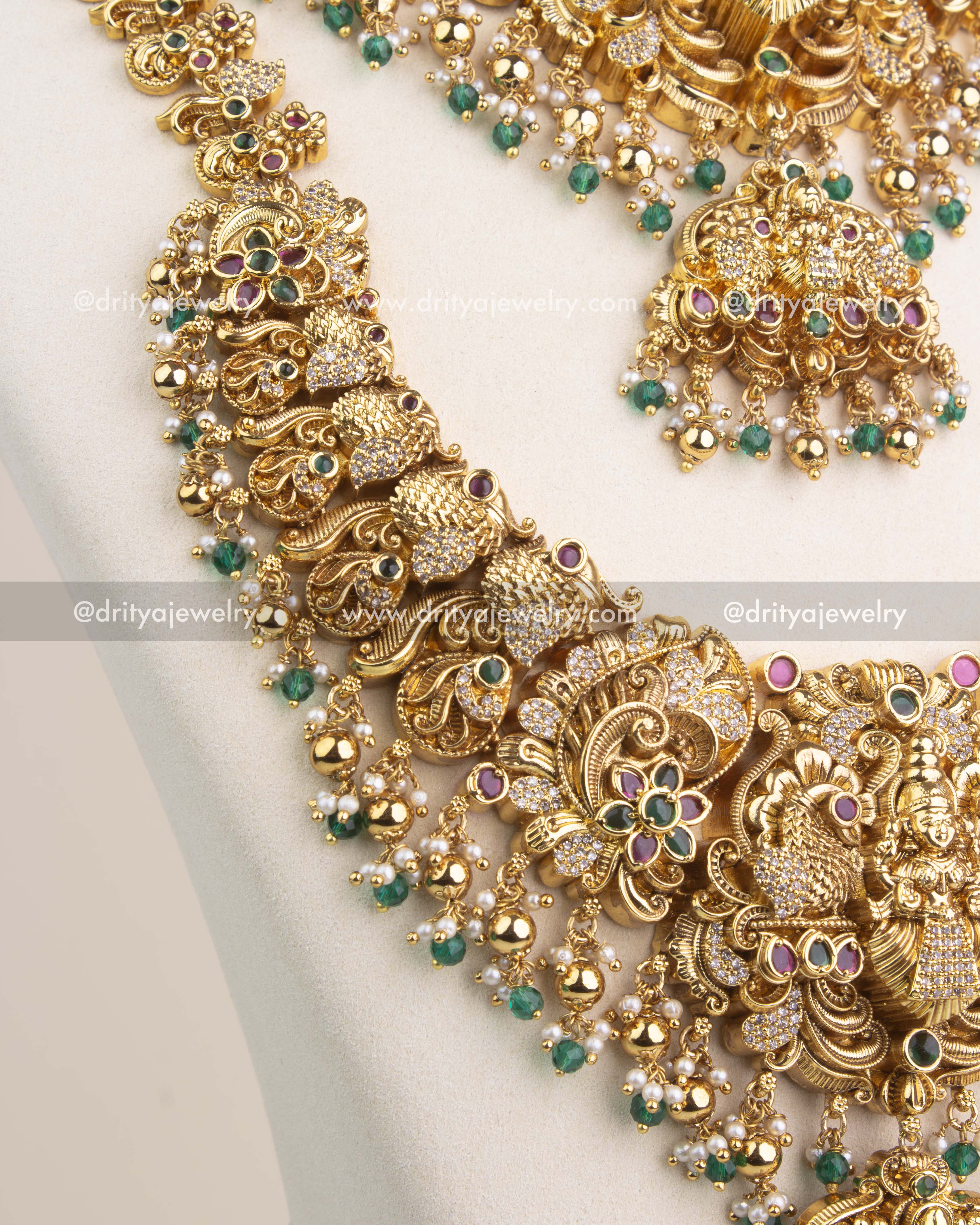 Close-up of Nakshi temple long necklace with Lakshmi pendant, emerald green stones and CZ accents.