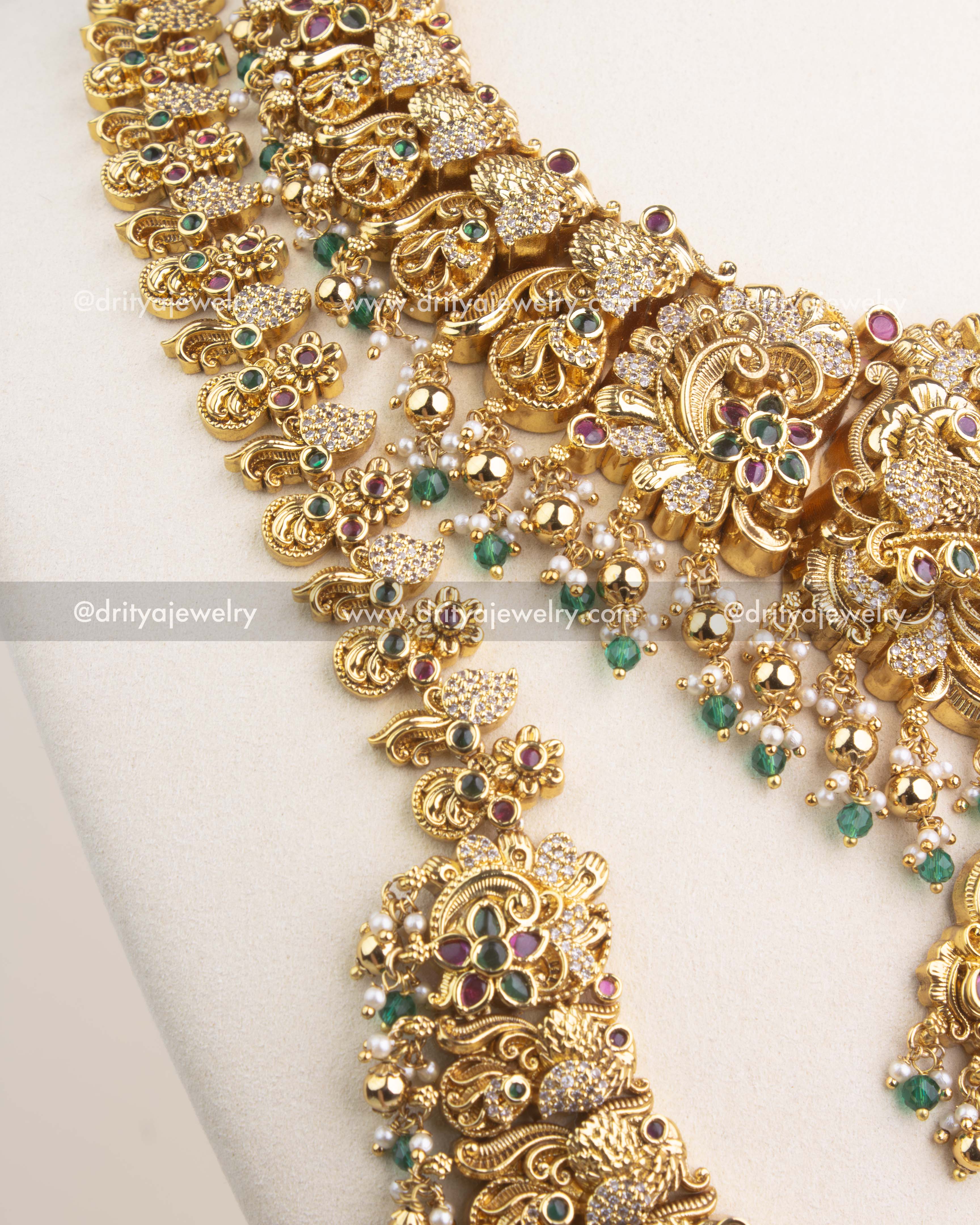 Close-up of Nakshi temple long necklace with Lakshmi pendant, emerald green stones and CZ accents.