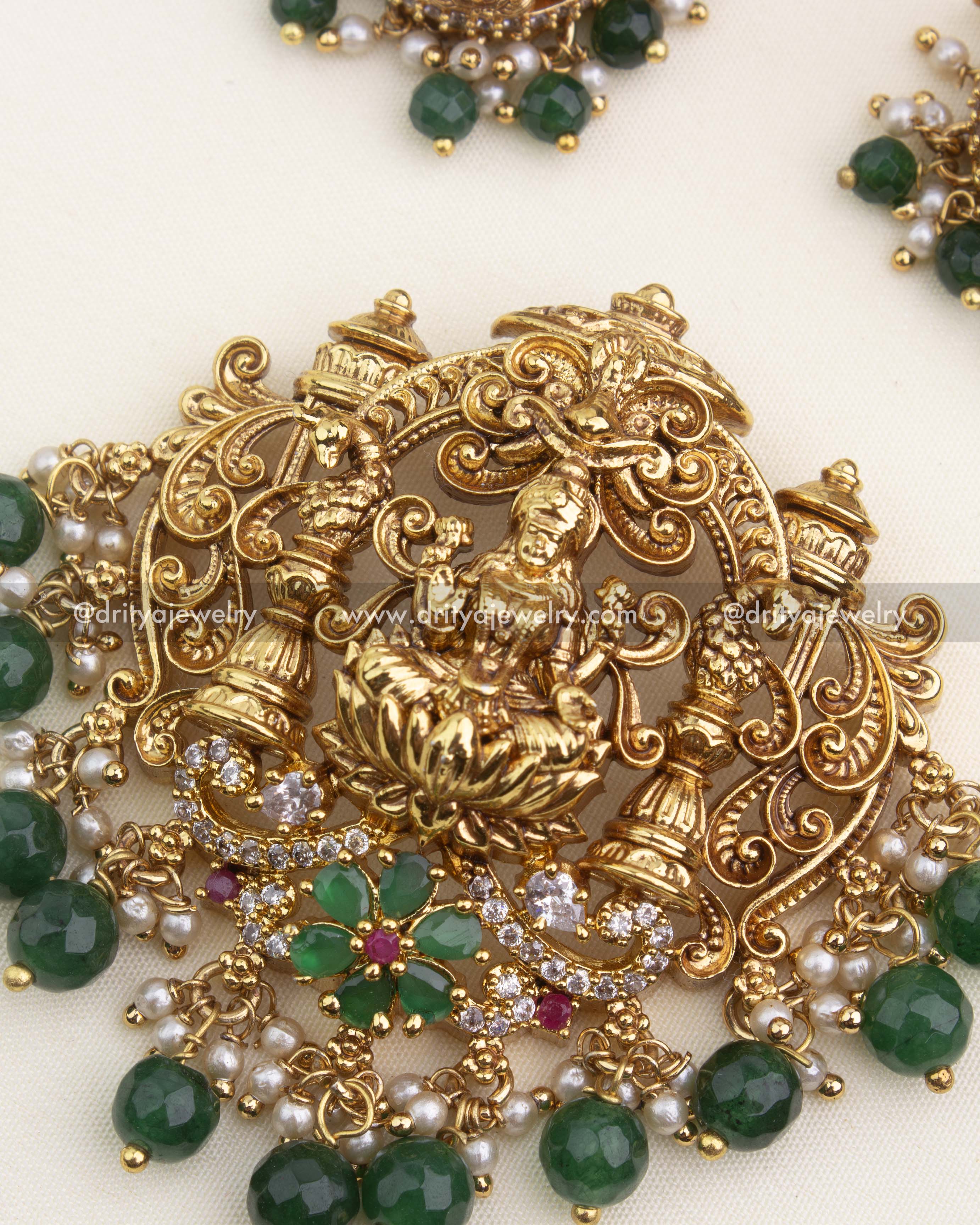 Intricate temple pendant featuring Goddess Lakshmi, pillars, CZ stones, green beads, and pearl clusters.