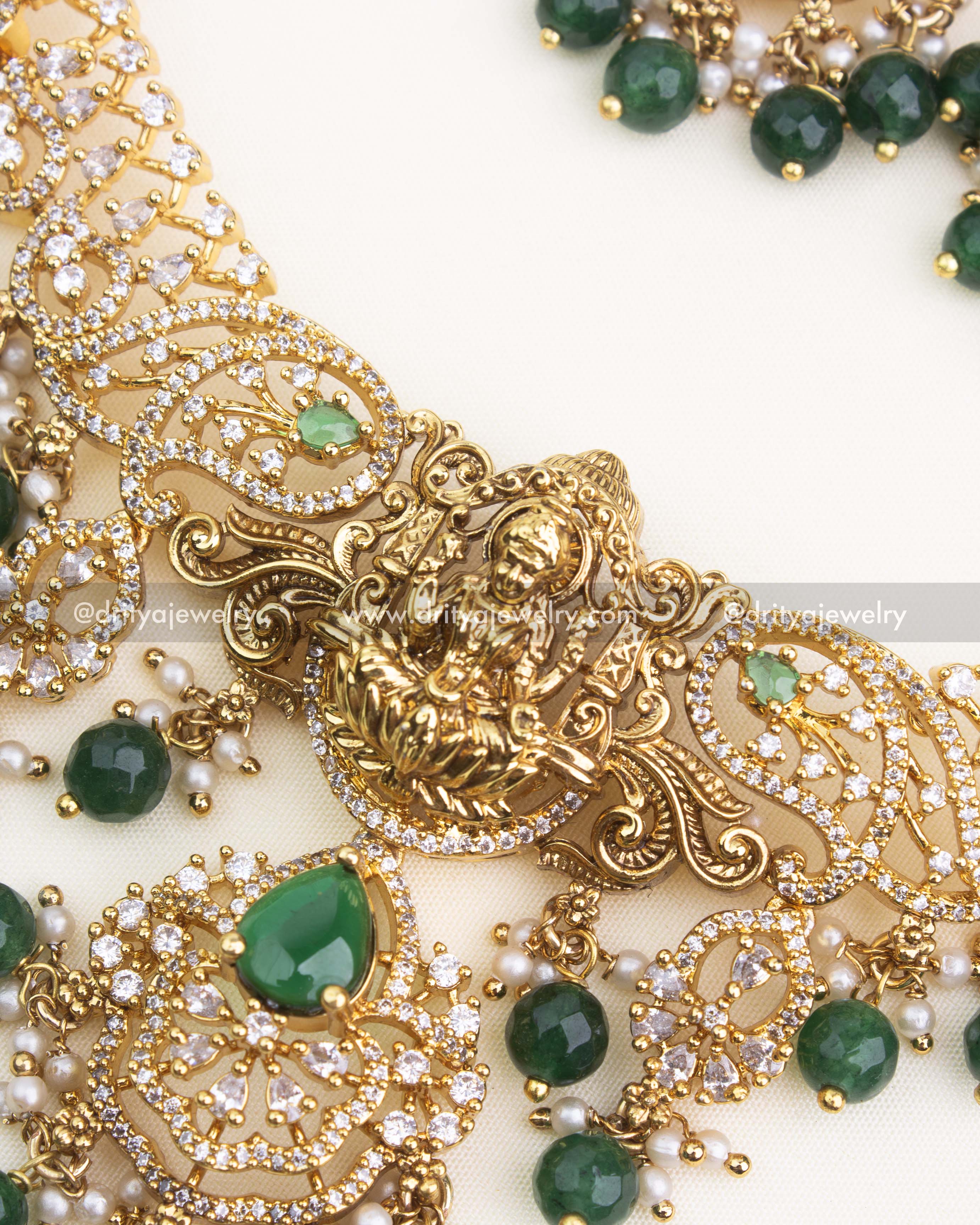 Close-up view of Lakshmi nakshi pendant with CZ stones and emerald green teardrop stone detailing.