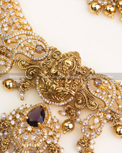 Intricate close-up of temple nakshi detailing and CZ work with purple teardrop stone.
