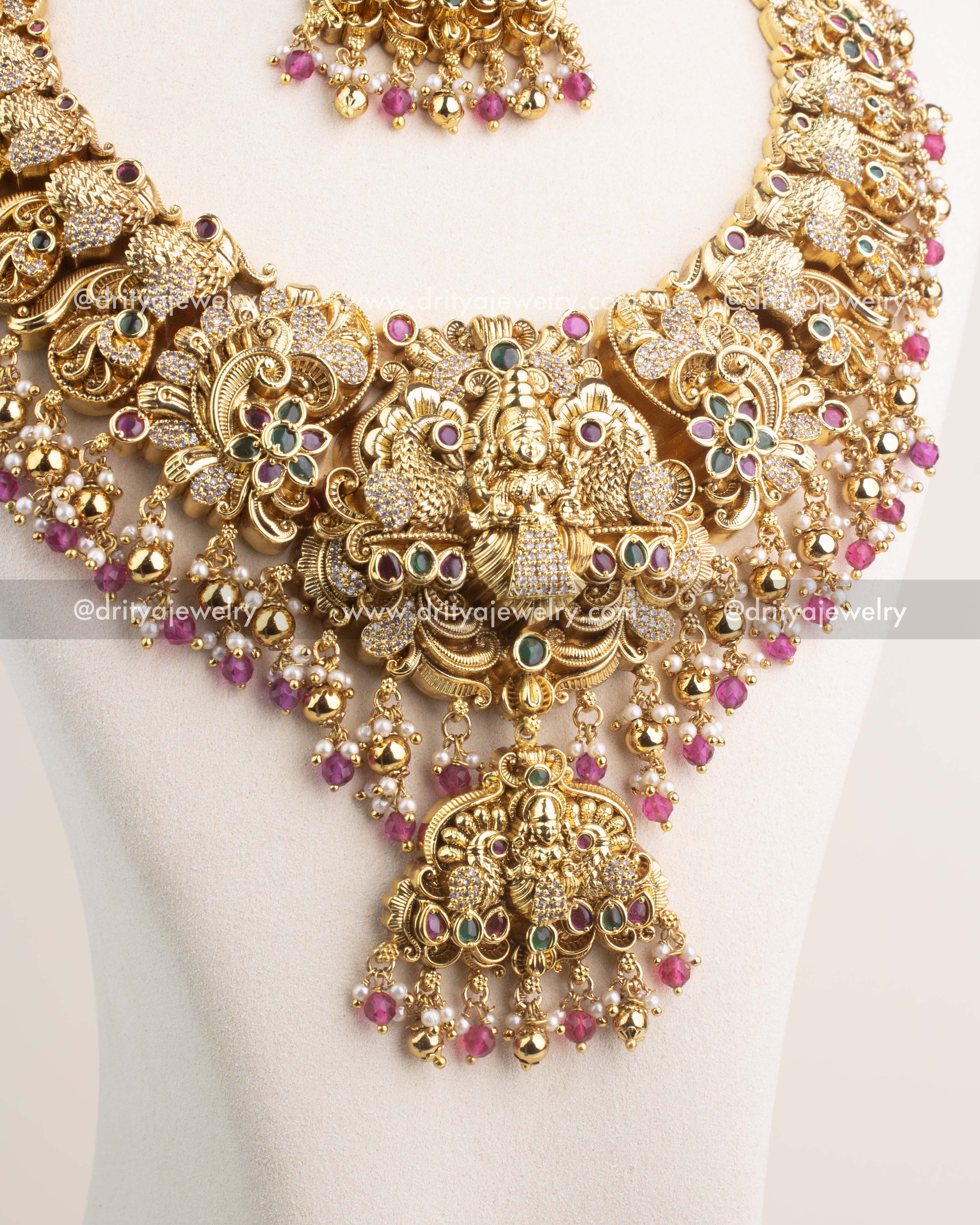 Close-up of Nakshi temple necklace with CZ stones and ruby pink bead hangings.