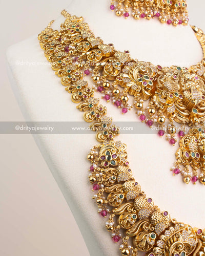 Close-up of Nakshi temple necklace with CZ stones and ruby pink bead hangings.