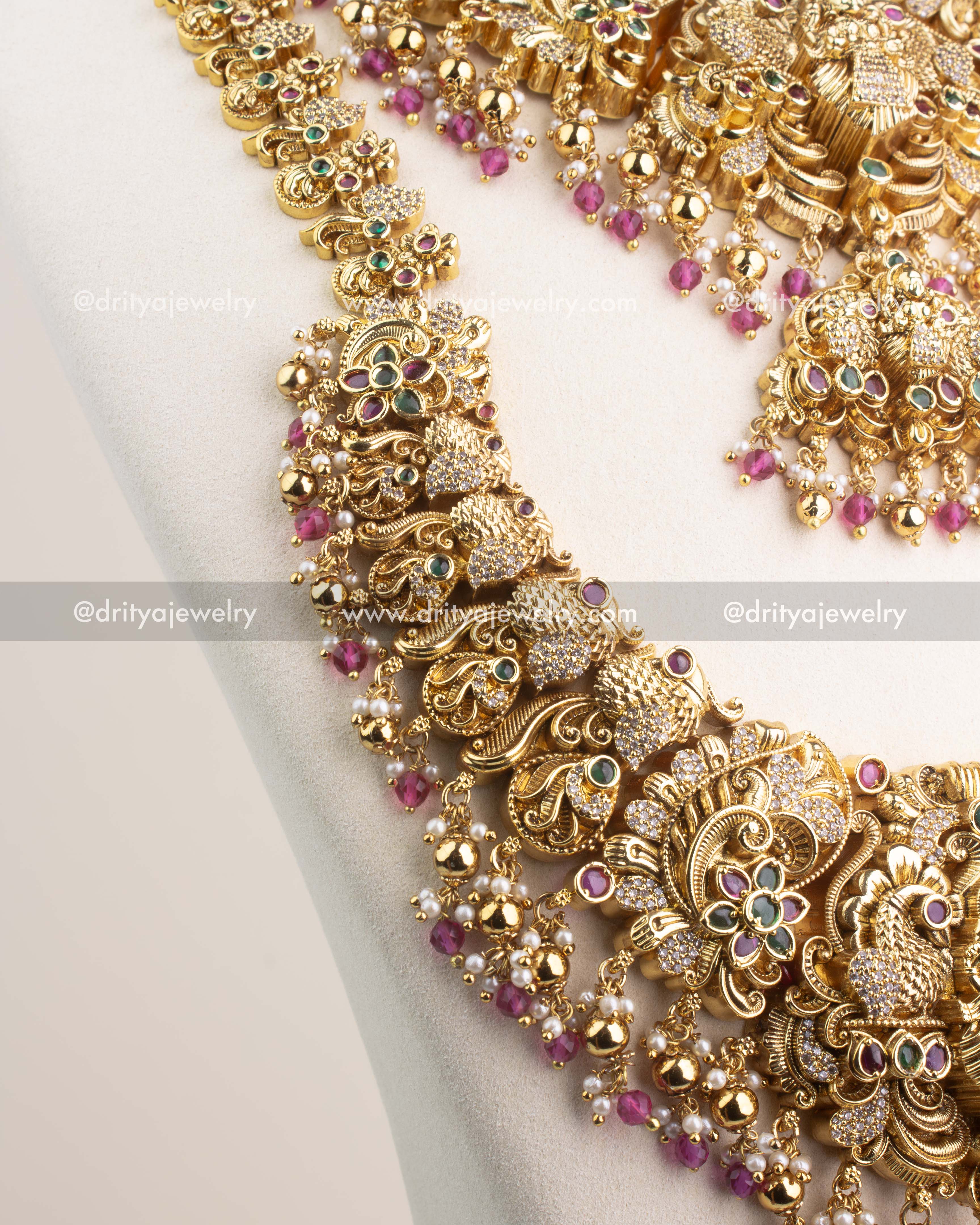 Close-up of Nakshi temple necklace with CZ stones and ruby pink bead hangings.