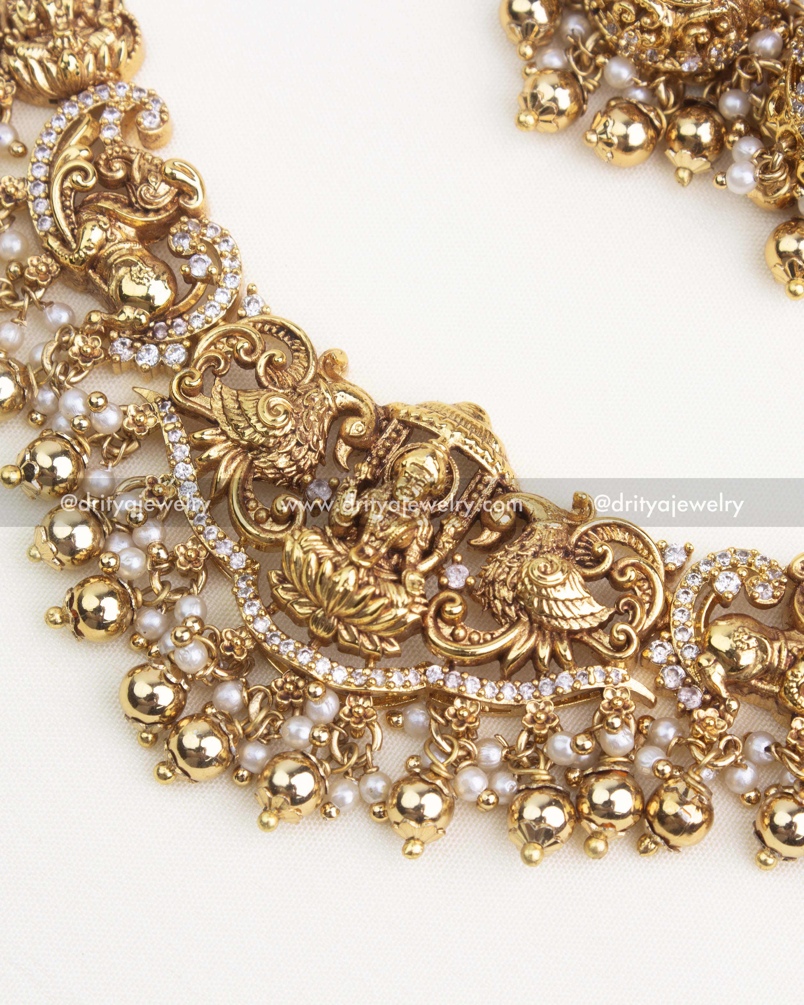 Close-up of temple-style Lakshmi pendant with nakshi carvings, AD work, and pearl–gold bead hangings