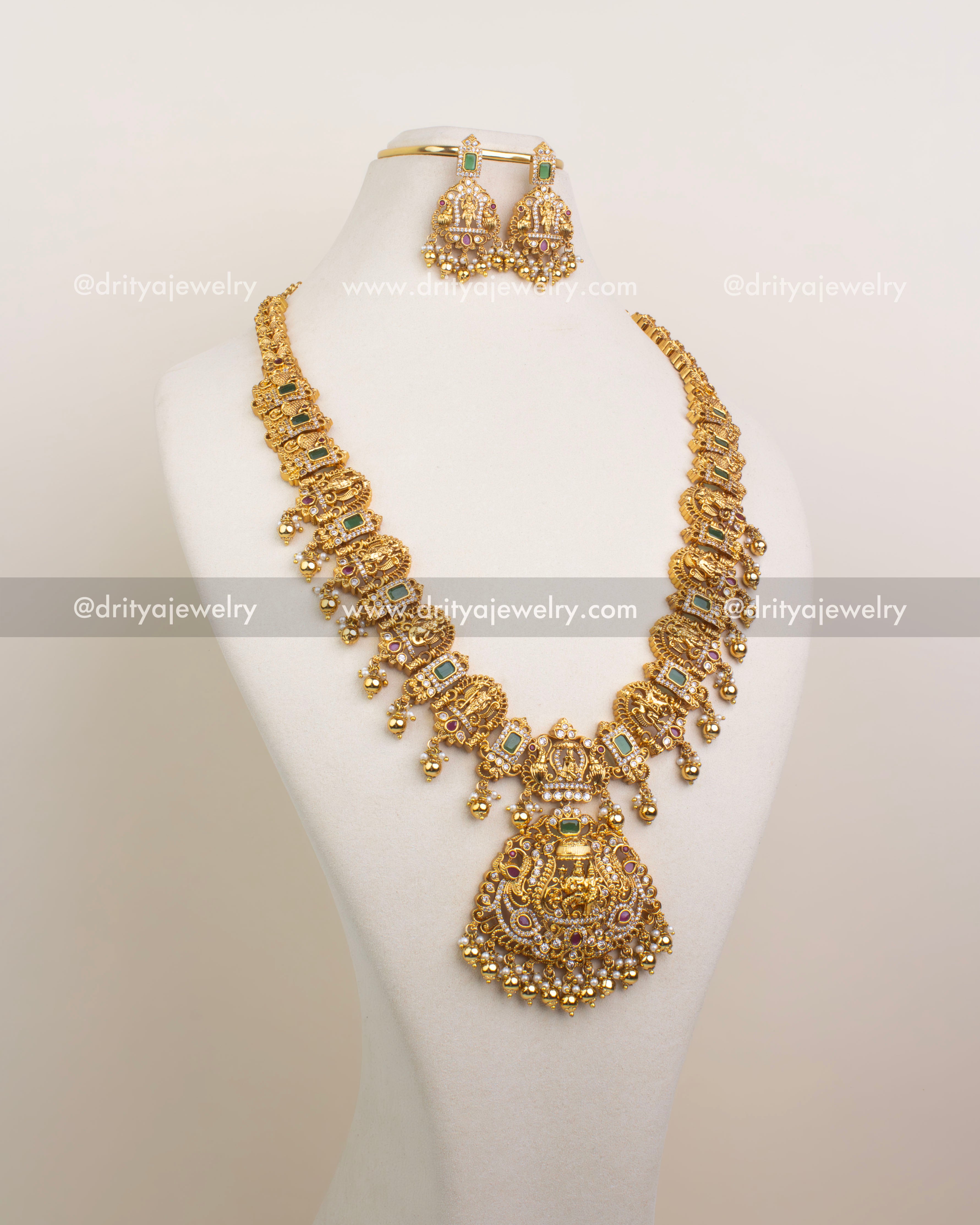 Antique gold necklace set featuring Lord Narasimha pendant with peacocks, ruby-emerald stones, and pearl ball drops.