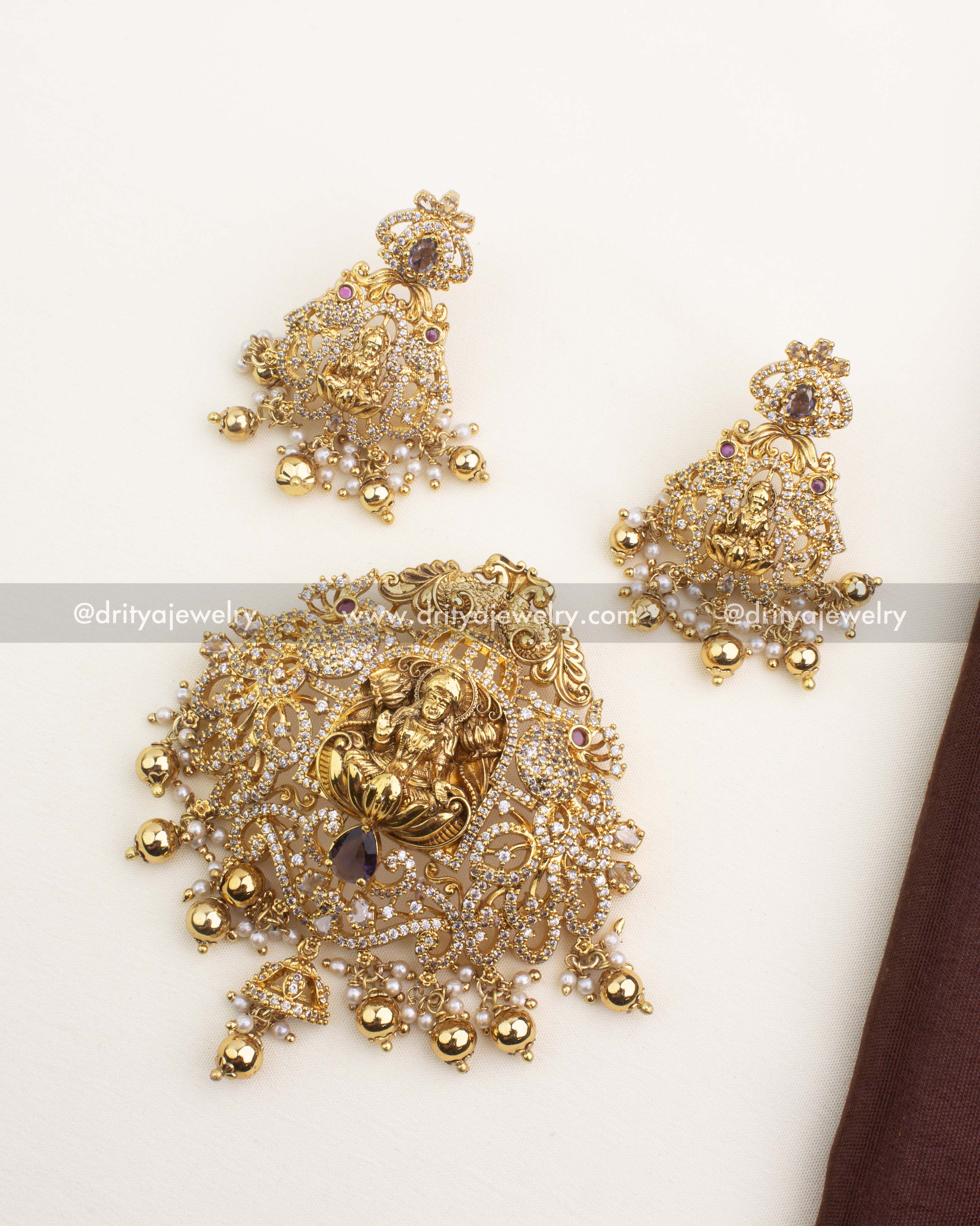 Gold temple pendant set with Lakshmi design, CZ detailing, and a purple teardrop centerpiece.