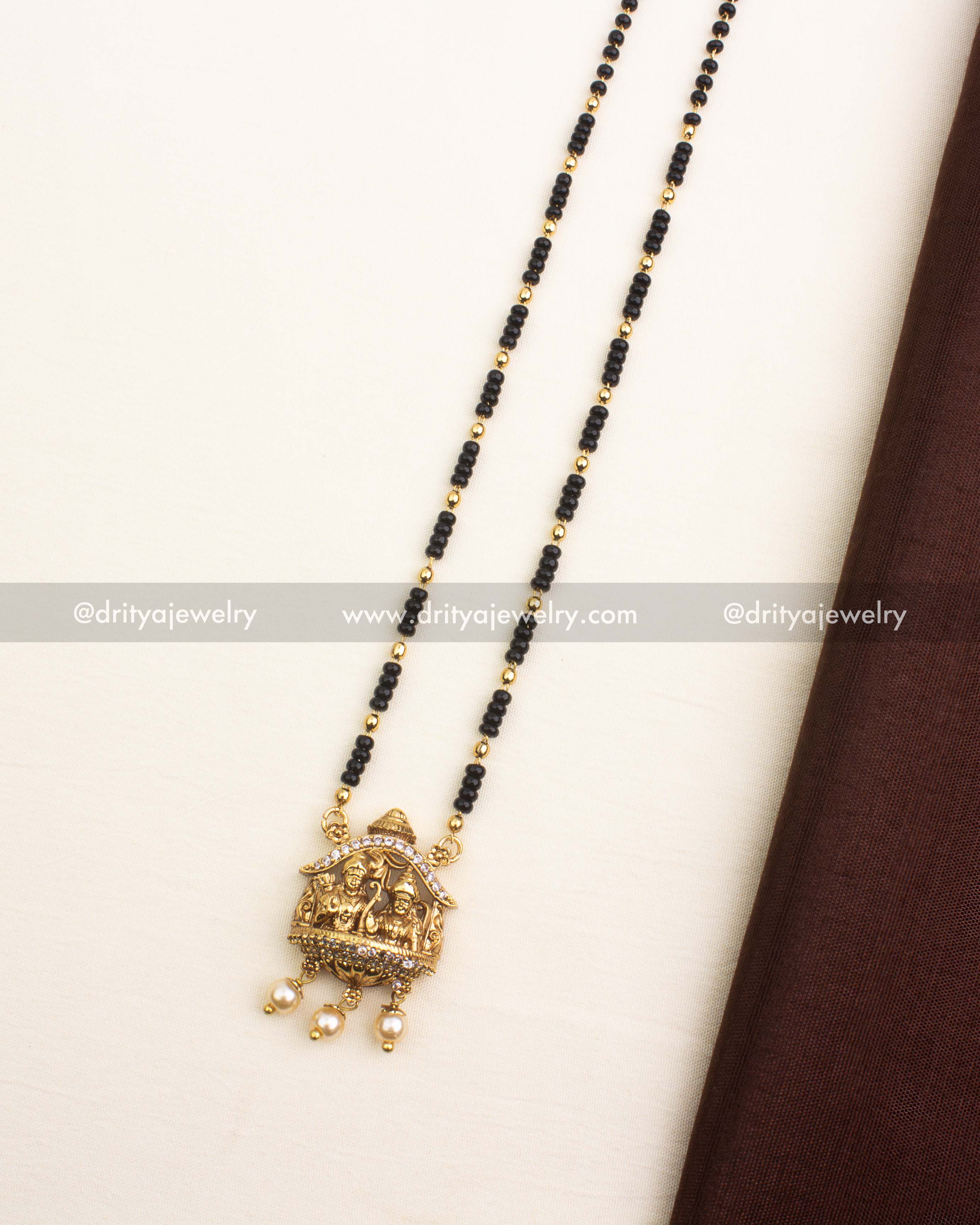 Antique gold pendant featuring god idol motif, CZ accents, and pearl hangings.