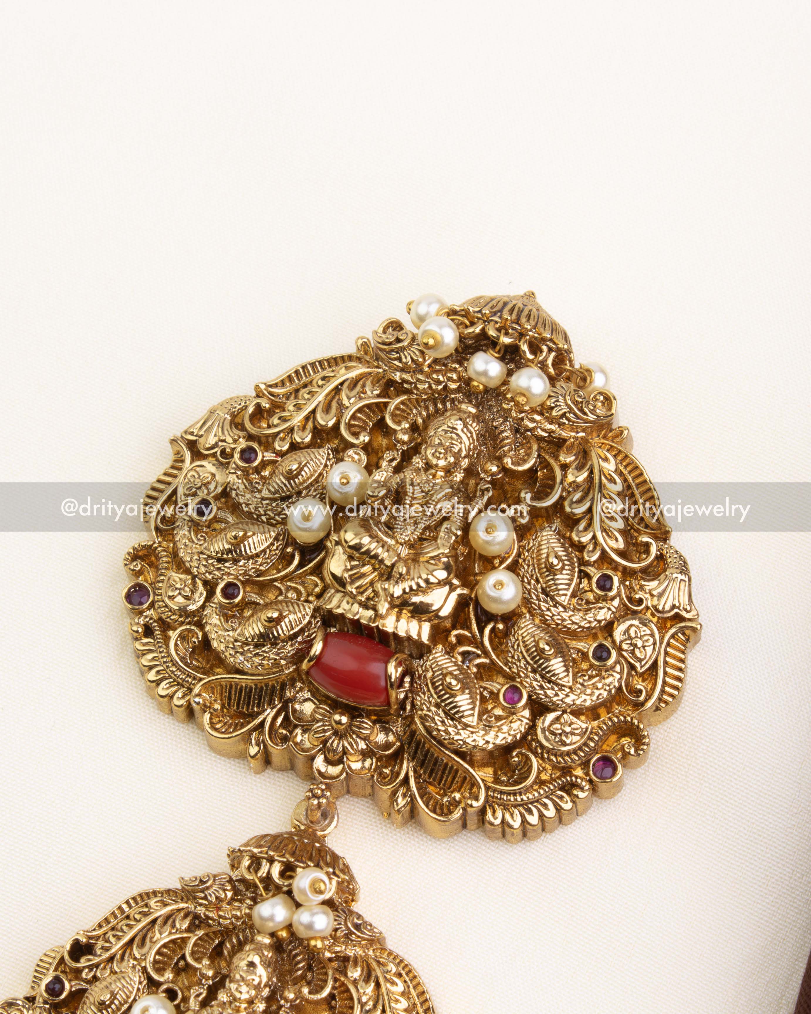 Detailed view of Lakshmi Devi carving and pearl-studded design on the top tier