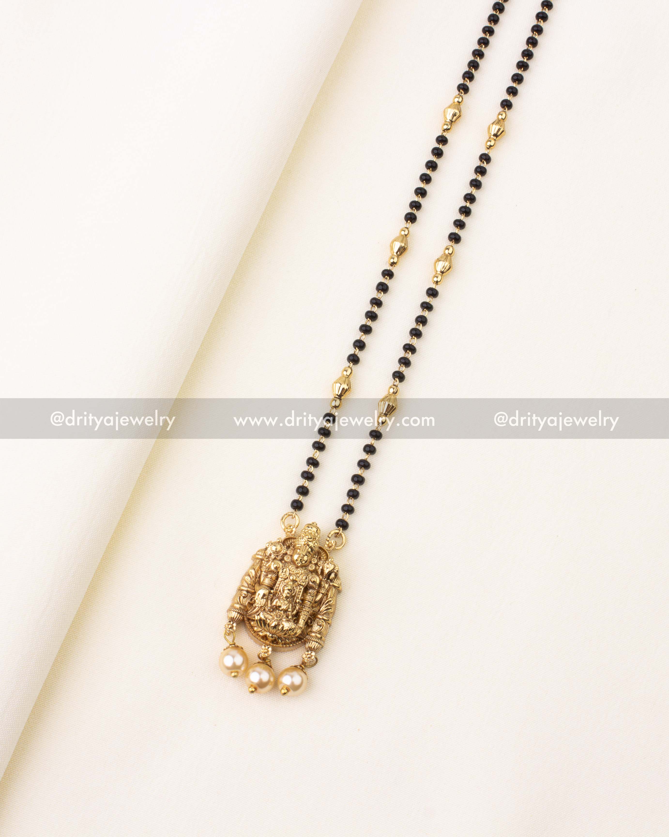 Elegant mangalsutra with glossy black beads, antique gold pendant of Lord Venkateswara Swamy, and pearl danglers.