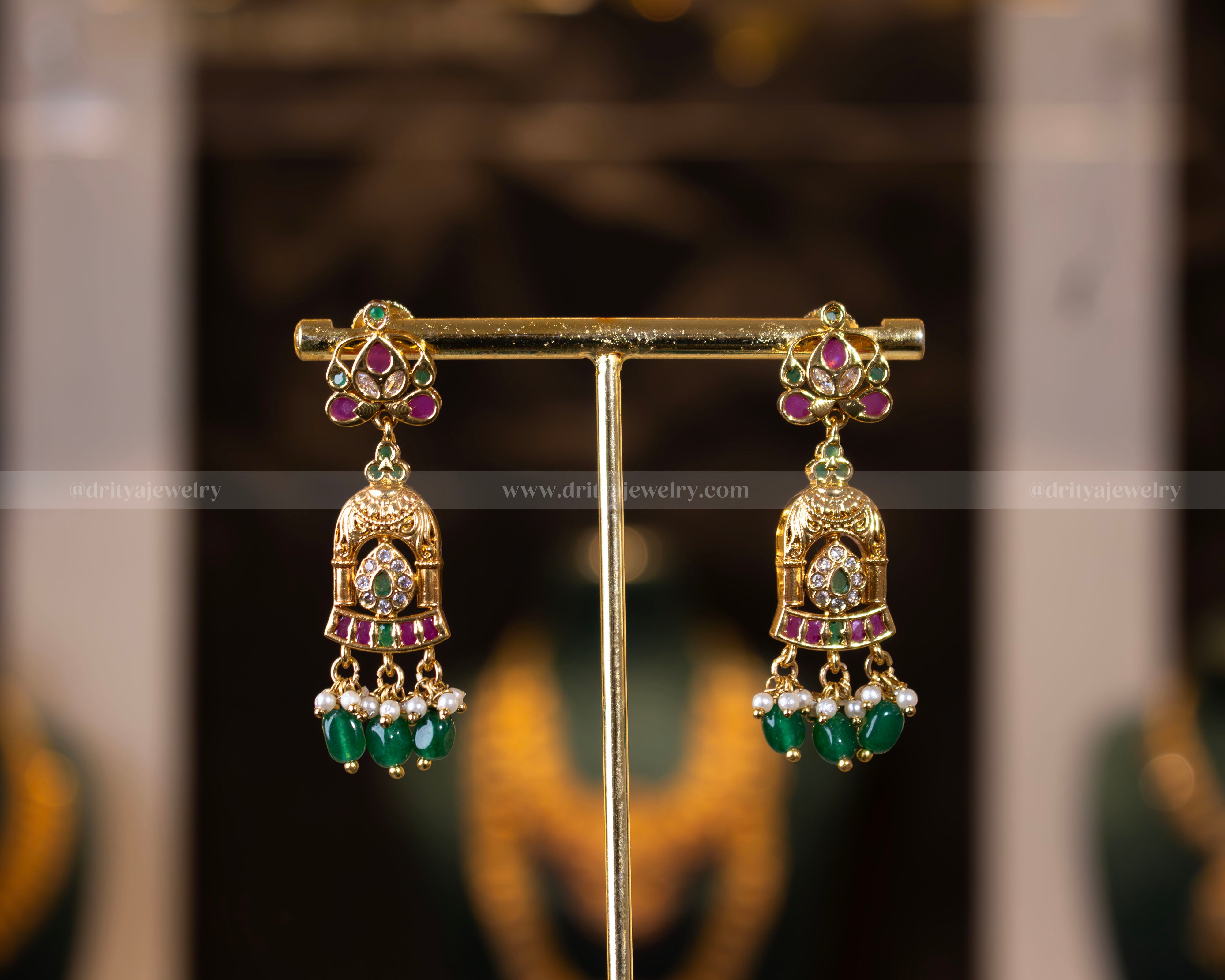 Pair of gold-plated traditional earrings with ruby, emerald stones, and green bead accents from Dritya Jewelry’s temple necklace set.