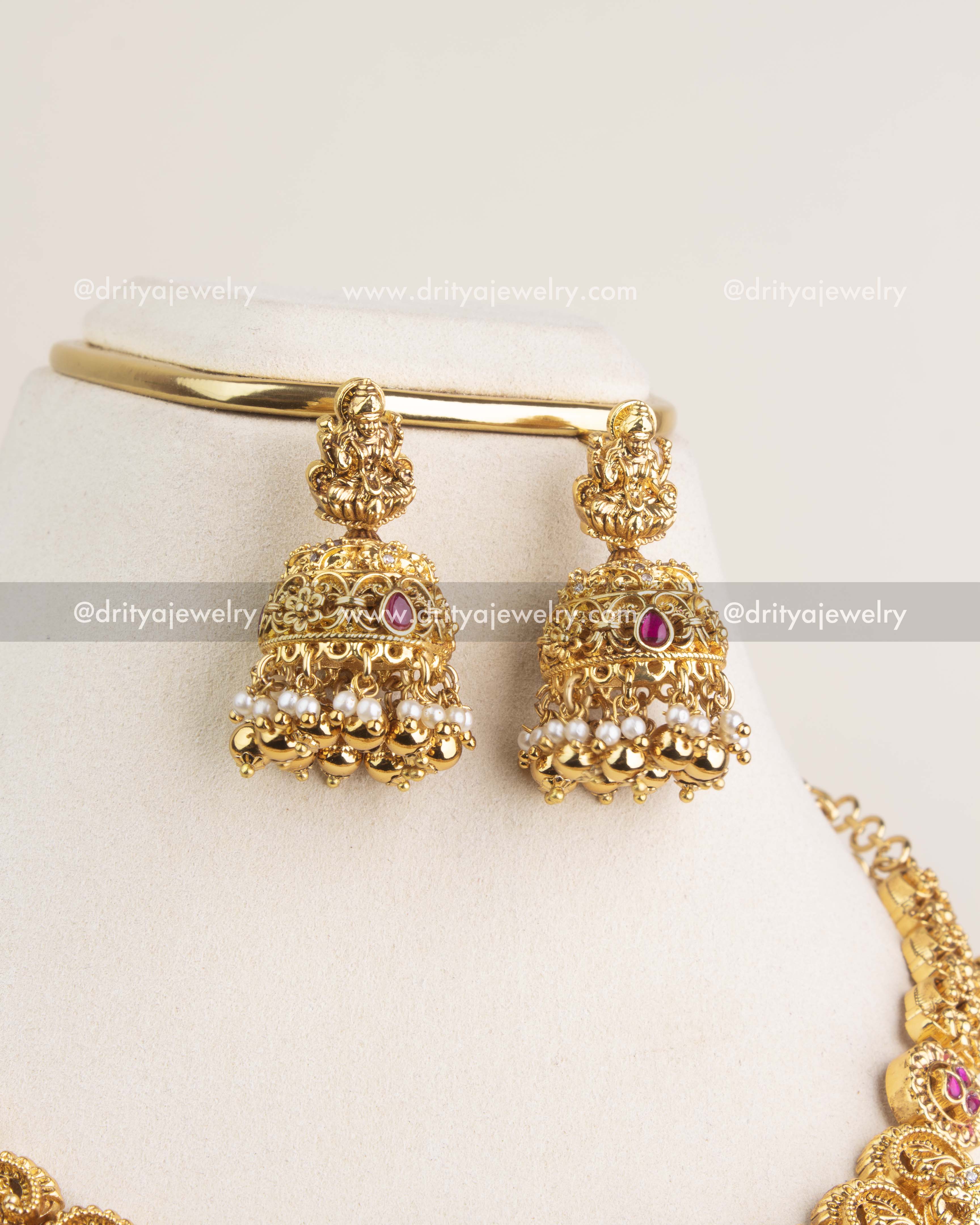 Nakshi temple-style jhumkas with kemp stones, pearl clusters, and antique gold polish.
