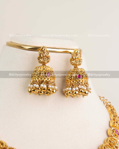 Nakshi temple-style jhumkas with kemp stones, pearl clusters, and antique gold polish.