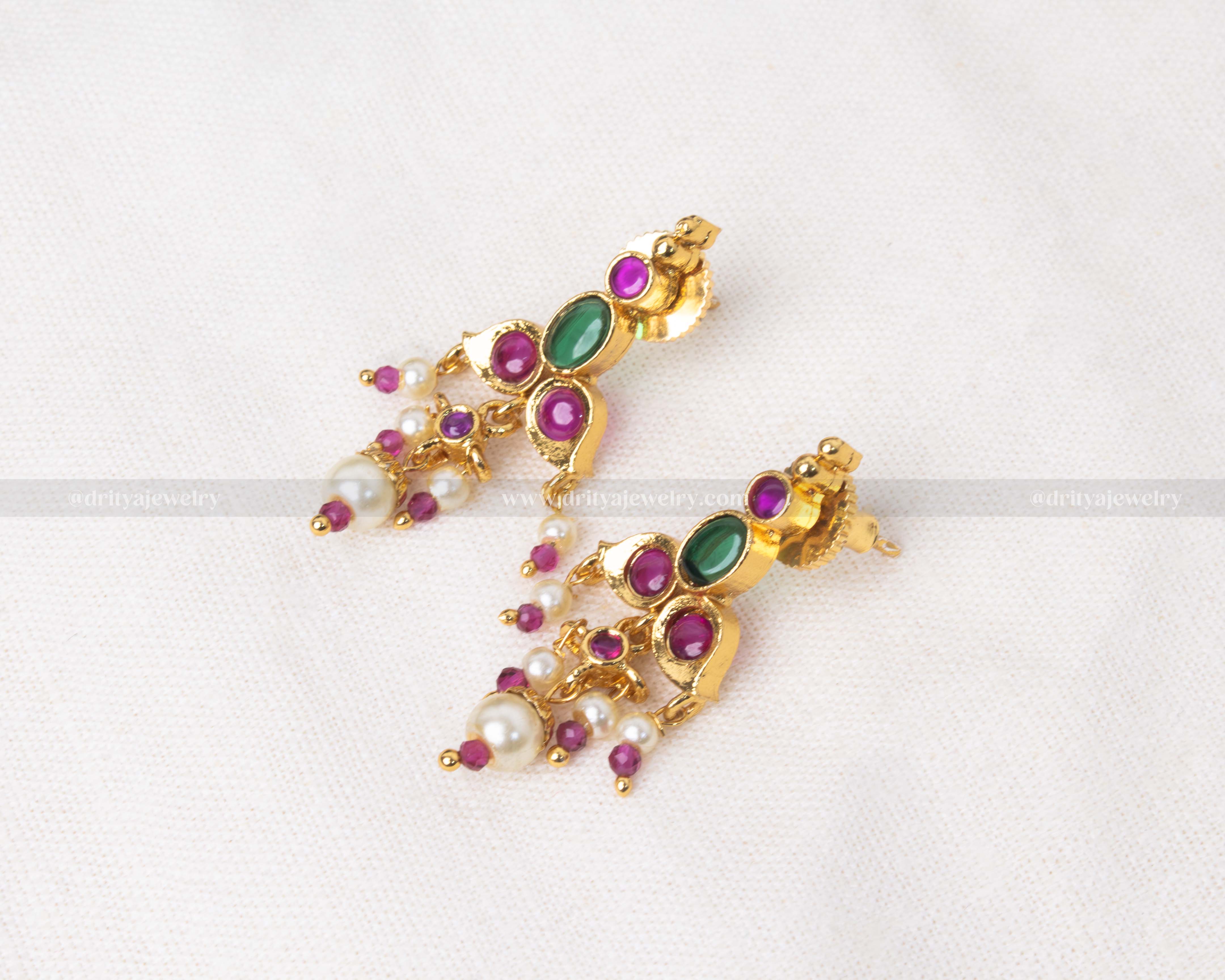 South Indian-style Kemp earrings with green and ruby red stones and pearl danglers in a gold-tone finish.