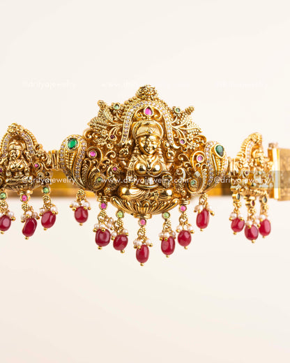 Detailed close-up of Lakshmi motif with peacock carvings and ruby-emerald accents.